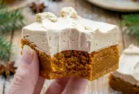 A festive tray of Frosted Gingerbread Brownies with creamy topping, styled as Gingerbread Bars With Frosting for a holiday dessert board.
