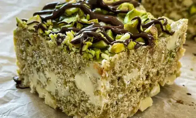 Pistachio and White Chocolate Rice Krispies Treats are styled as Pistachio Topped Treats with chopped nuts and a rich chocolate drizzle.