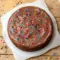 A rich slice of Cosmic Brownie Cheesecake for Creative Cooking Ideas, topped with glossy ganache and colorful candy-coated chips.
