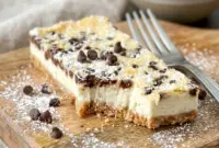 Cannoli Cheesecake Bars served chilled on a plate, a creamy Cannoli Desserts favorite with chocolate chips.