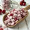 A sweet bowl of Cherry Cheesecake Puppy Chow finished with powdered sugar and cherries, perfect for Snack Exchange Ideas.